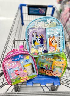 three children's backpacks sitting on top of a shopping cart