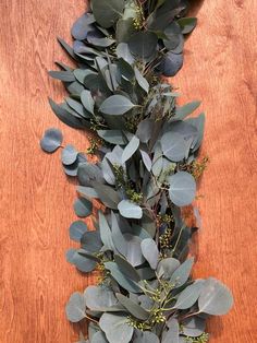 some green leaves and branches on a wooden table