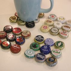 a blue mug sitting on top of a table filled with bottle caps