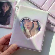 a person holding up a heart shaped photo frame