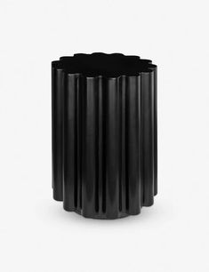 a black vase sitting on top of a white table