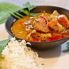 a bowl filled with meat and vegetables next to rice