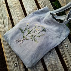 an embroidered bag sitting on top of a wooden bench