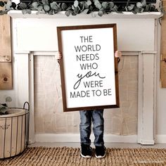 a young boy holding up a sign that says the world needs who you were made to be