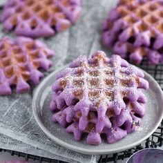 purple waffles on a plate with powdered sugar