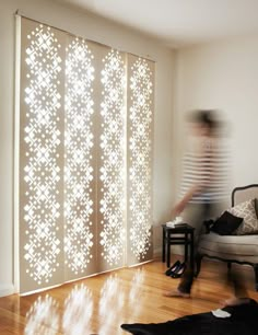 a person is walking in front of a window with white lights on it and an open screen