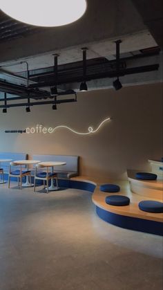 the interior of a coffee shop with circular tables and stools