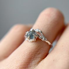 a woman's hand with a diamond ring on top of her finger and an engagement band