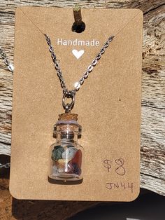 there is a small jar with rocks in it on a card that says handmade