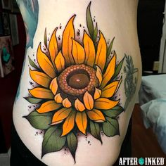 a woman's stomach with a sunflower tattoo on it