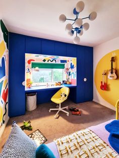 a bedroom with blue walls and yellow accents on the wall, including a desk in front of a large window