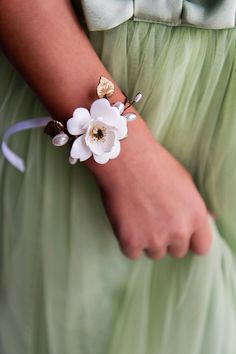 a close up of a person wearing a bracelet with flowers on it