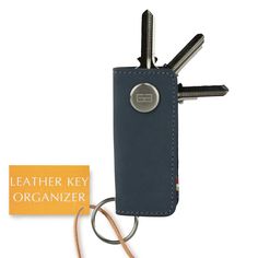 a leather key holder with two keys in it and a tag attached to the back