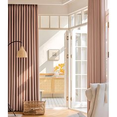 a living room filled with furniture and pink curtains