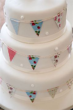 a three tiered cake with bunting flags on it