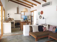 a living room filled with furniture next to a kitchen