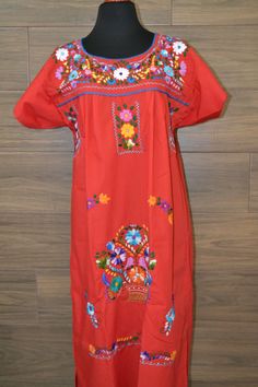 "This lovely red was handmade in Mexico. The beautiful colorful flowers were embroidered by hand, so each one is unique. You will love wearing this comfortable cotton dress with short sleeves. It is perfect for a hot summer day. This dress comes just above or below the knee, depending on how tall you are. It has a square neckline and cute little puffy sleeves. The measurements on this dress are 21\" wide x 44\" long. It has a 9\" opening for the neck and 10\" sleeve openings. Size Large About Ou Summer Dresses With Traditional Patterns For Ceremonies, Traditional Patterned Dresses For Summer Ceremonies, Red Bohemian Embroidered Dress With Intricate Embroidery, Red Bohemian Embroidered Dress With Floral Print, Red Bohemian Embroidered Dress With Floral Details, Red Bohemian Dress With Floral Embroidery, Traditional Red Embroidered Spring Dress, Red Folk Style Floral Print Dress, Traditional Red Embroidered Dress For Spring