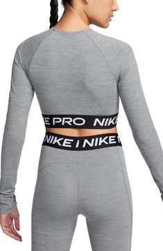 Nike Pro lettering details the stretchy, cropped hem of a second-skin top designed with sweat-wicking Dri-FIT tech that helps you stay dry and comfortable. 13 1/2" length (size Medium) Crewneck Long sleeves with thumbhole cuffs Dri-FIT moisture-wicking technology 83% polyester, 17% spandex Machine wash, dry flat Imported Functional Sports Crop Top With Crew Neck, Functional Crew Neck Crop Top For Sports, Go-dry Cropped Sports Top, Athleisure Letter Print Crop Top For Gym, Nike Athleisure Crop Top For Sports, Nike Sporty Crop Top For Workout, Sporty Gray Crop Top For Sports, High Stretch Tops For Sports Events, Nike Functional High Stretch Tops