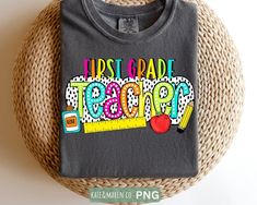 a t - shirt with the words first grade teacher on it sitting next to a wicker basket