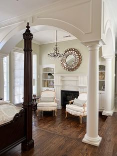 a bedroom with white furniture and wood floors