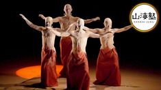 four people dressed in red are standing on the stage with their arms spread out and hands extended