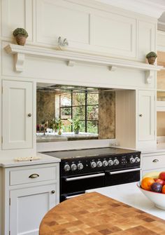 a bowl of fruit sitting on top of a counter next to a stove and oven