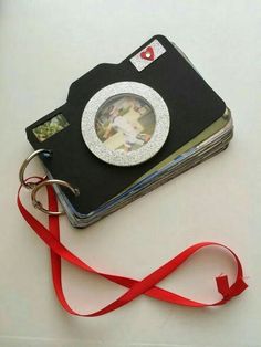 a photo album with a red ribbon around it and a camera on the front cover