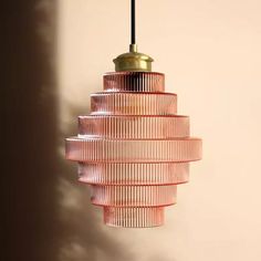 a pink glass light hanging from a ceiling