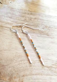 Light cream, soft pink, turquoise, and mustard seed bead earrings, Choice of gold or silver finish. Lead/nickel free silver hooks with rubber backs. 2 ¹/⁴ inches long. Return to shop 👇 https://wyldsparrowjewelry.etsy.com PLEASE MAKE SURE YOUR ADDRESS IS ENTERED CORRECTLY. IF YOU ARE DOING A GUEST CHECKOUT PLEASE PLEASE DOUBLE CHECK YOUR ADDRESS AND YOUR EMAIL. THANK YOU! *All feathers are cruelty free.  All hooks are lead and nickel free. All leather is genuine leather. *Please feel free to contact me with ANY questions or custom creations. *Please understand that each feather is unique and natural so with that comes variances. *The time it takes me to get you your earrings depends on current order volume, if you need them by a specific date please feel free to message me and I'll do my b Ombre Beaded Earrings, Minimalist Adjustable Earrings With Tiny Beads, Nickel Free Bohemian Beaded Earrings, Nickel-free Bohemian Beaded Earrings, Bohemian Nickel Free Beaded Earrings For Everyday, Nickel Free Bohemian Beaded Earrings For Everyday, Everyday Bohemian Nickel-free Beaded Earrings, Dainty Dangle Beaded Earrings, Dainty Beaded Drop Earrings