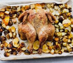 roasted chicken with potatoes and lemons on a sheet of parchment paper, ready to be cooked