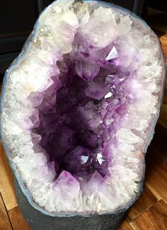 a purple and white rock sitting on top of a wooden floor