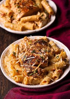 two plates with pasta and meat on them