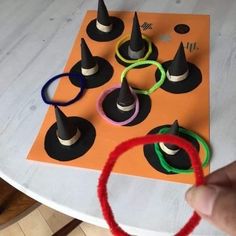 a hand is holding an item with yarn around it on top of a white table