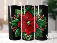 two black tumblers with red poinsettis and holly on them