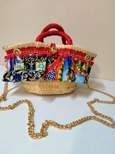 a basket with many colorful items in it on a white table next to a gold chain