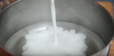 milk being poured into a large metal bowl