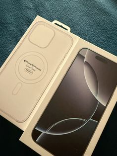 an apple iphone in its box sitting on a blue cloth covered bedding area with the packaging open