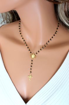 "This is a rosary style necklace made of 3mm black spinel gemstones on gold vermeil (24kt gold over 925 sterling silver). The beautiful center pendant is the Seven Sorrows of Mary Emblem in gold vermeil measuring 3/4\"x1/2\". Necklace may be ordered in a 16\", 18\" or 20\" length. This is the length around the neck only. There is a 2 3/4\" drop which includes a 3/4\" gold vermeil cross pendant. Necklace has a spring clasp closure in back. Comes nicely boxed, the perfect gift! Available in sterli Crucifix Jewelry With Black Beads As Gift, Black Crucifix Jewelry For Jewelry Making, Spiritual Black Lariat Necklace, Dainty Gold Necklace With Black Beads, Spiritual Gold Necklace With Black Beads, Gold Pendant Jewelry With Black Beads, Yellow Gold Jewelry With Black Beads For Gifting, Yellow Gold Jewelry With Black Beads For Gift, Yellow Gold Jewelry With Black Beads As Gift