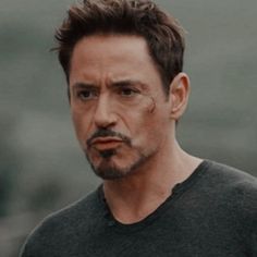 the man is wearing a black shirt and has his face painted like iron - man