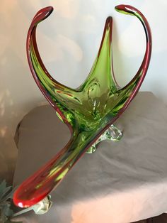 a green and red glass sculpture sitting on top of a table