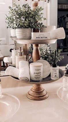 a bathroom sink with soap and lotion on it's counter top, surrounded by plants