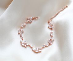 Add a touch of sophistication to your bridal look with our stunning rose gold tennis bracelet. Each delicate link features sparkling cubic zirconia, ensuring you shine on your special day. Elevate your jewelry collection with this luxurious and timeless piece. - Created with Premium Cubic Zirconia stones - Available in rose gold, yellow gold, and rhodium finish. - Bracelet measures 6.25 inches long, extends to 9.5 inches - Nickel free and hypoallergenic - PLEASE ALLOW APPROX 3 DAYS FOR COMPLETIO Rose Gold Crystal Bracelet With Sparkling Stones For Wedding, Dainty Diamond Bracelet With Sparkling Stones For Wedding, Delicate Cubic Zirconia Wedding Bracelet, Dainty Wedding Diamond Bracelet With Sparkling Stones, Rose Gold Jubilee Tennis Bracelet For Wedding, Rose Gold Cubic Zirconia Tennis Bracelet For Party, Party Rose Gold Cubic Zirconia Tennis Bracelet, Delicate Rose Gold Cubic Zirconia Bracelets, Adjustable Rose Gold Tennis Bracelet For Wedding