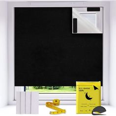 a window with black roller shades and yellow tape next to it, along with other items