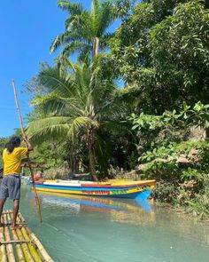 a man standing on top of a wooden raft in the water