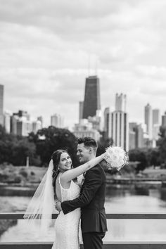 a bride and groom pose for a photo in front of the chicago skyline