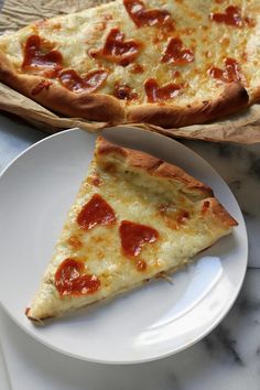 two slices of pepperoni pizza sitting on top of a white plate next to each other