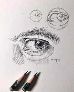 some pencils are laying on top of a paper with an eye drawn in it