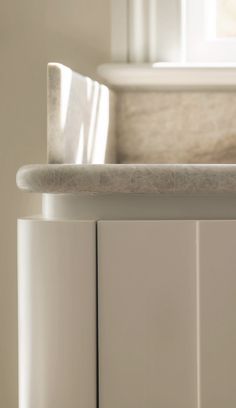 a close up view of a sink and counter top in a bathroom with white cabinets