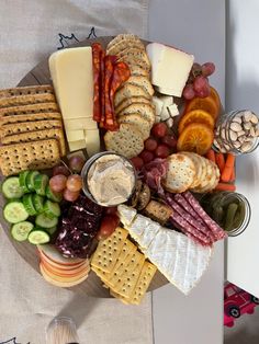 a platter filled with cheese, crackers and vegetables