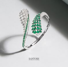 This gorgeously crafted bangle, embellished with the finest diamonds and emeralds, weaves a tale of artistry and sophistication. Each delicate curve whispers secrets of impeccable design and craftsmanship. A radiant beacon of beauty that deserves to be cherished. #JewelryArtistry #DiamondsAndEmeralds #ElegancePersonified #middleeast #santoshjewellers #jewelerygram #diamonds #jewels #jewelsofinstagram #uaejewellery #finejewellery #jewellerydesign #uae #middleeast #doha #dubai🇦🇪 #qutar Bracelet Jewelry Design, Breslate Design, Female Rings, Band Diamond Ring, Silver Bracelet Designs, Oval Bangle, Beautiful Jewelry Diamonds, Neck Pieces Jewelry, Diamond Bangles